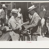 Salesman displaying sample of suit material to farmer, Hammond, Louisiana