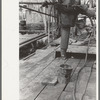 Pushing length of pipe into the rat hole, oil well, Kilgore, Texas