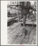 Pushing length of pipe into the rat hole, oil well, Kilgore, Texas