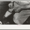 Attaching piece of leather into arch of sole before fasteining with wooden pegs. Bootmaking shop, Alpine, Texas