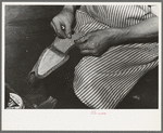 Attaching piece of leather into arch of sole before fasteining with wooden pegs. Bootmaking shop, Alpine, Texas