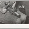 Nailing foot of boot to sole, in order to hold in place when sewing foot to welt. These nails are removed after sewing. Bootmaking shop, Alpine, Texas