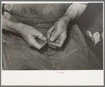 Threading a needle with waxed thread. Bootmaking shop, Alpine, Texas