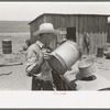 Pouring gasoline into tractor, large farm near Ralls, Texas. Man is day laborer