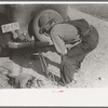 Mr. Milton, farmer at El Indio, stretching barbed wire by means of block and tackle attached to automobile