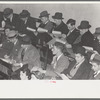 Group of buyers at strawberry auction, Hammond, Louisiana. Third man from right in front row is bidding