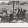 Schoolchildren on circular swing, San Augustine, Texas