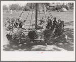 Schoolchildren on circular swing, San Augustine, Texas