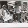 Two farmers talking to popcorn man, San Augustine, Texas