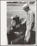 Farmer changing license plates, San Augustine, Texas