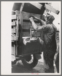 Tying lantern onto the back of improvised truck which will travel to California near Muskogee, Oklahoma