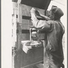 Tying the lantern onto the back of improvised truck which will travel to California near Muskogee, Oklahoma