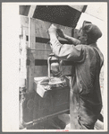 Tying the lantern onto the back of improvised truck which will travel to California near Muskogee, Oklahoma