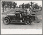 Migrant getting out of car with pail to get some water. Encamped along roadside near Henrietta, Oklahoma