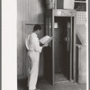 Man looking up telephone number. Streetcar terminal, Oklahoma City, Oklahoma