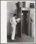 Man looking up telephone number. Streetcar terminal, Oklahoma City, Oklahoma