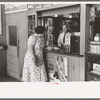 Tobacco stand keeper talking with woman. Streetcar terminal, Oklahoma City, Oklahoma