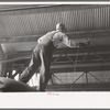 Worker replacing wheel in end of streetcar. Terminal, Oklahoma City, Oklahoma