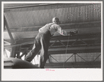 Worker replacing wheel in end of streetcar. Terminal, Oklahoma City, Oklahoma
