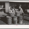 Grocery boy leaning on basket of peaches, Muskogee, Oklahoma