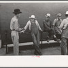 Men leaning and sitting on rail, Muskogee, Oklahoma