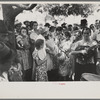 Group of people assembled under tree to listen to revival rally on Saturday afternoon, Tahlequah, Oklahoma