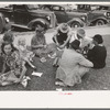 Farm people eating watermelon on lawn in front of courthouse, Tahlequah, Oklahoma