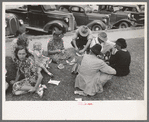 Farm people eating watermelon on lawn in front of courthouse, Tahlequah, Oklahoma