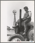 Mr. Germeroth, Farm Security Administration client sitting on tractor which was bought by means of FSA loan, Sheridan County, Kansas