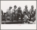 Farmers sitting on the fence at 4-H Club fair, Cimarron, Kansas