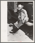 Mr. Johnson, FSA client with part interest in cooperative well, putting on his boots near Syracuse, Kansas