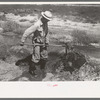 Mr. Johnson, FSA client, shovelling sediment out of the ditch to make the flow more rapid, Syracuse, Kansas