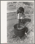 Spanish-American FSA client stirring kettle of soap, Taos County, New Mexico