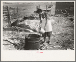 Spanish-American client adding water to soap in kettle, Taos County, New Mexico