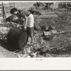 Spanish-American client rinsing soap kettle before using, Taos County, New Mexico