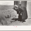 Determining temperature of earthen oven in which bread will be baked by seeing how fast straw will burn, Taos Co., N.M