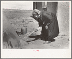 Determining temperature of earthen oven in which bread will be baked by seeing how fast straw will burn, Taos Co., N.M