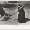Putting out hot coals with wet cloth, Taos Co., N.M