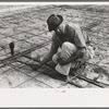 Fitting water pipe at migrant camp under construction at Sinton, Texas