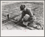 Fitting water pipe at migrant camp under construction at Sinton, Texas