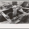 Laying bricks in construction of manhole at migrant camp at Sinton, Texas