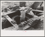 Laying bricks in construction of manhole at migrant camp at Sinton, Texas