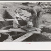 Laying bricks in construction of manhole at migrant camp at Sinton, Texas