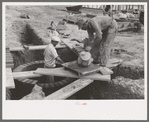 Laying bricks in construction of manhole at migrant camp at Sinton, Texas