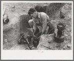 Soldering a joint of cast iron sewer pipe at migrant camp under construction at Sinton, Texas