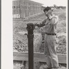 Working on sewer pipe connection at migrant camp under construction at Sinton, Texas