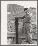 Working on sewer pipe connection at migrant camp under construction at Sinton, Texas