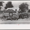 Farmer moving in wagon from farm to a new farm. He had stopped for rest and repair along roadside in Smith County, Texas