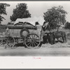 Farmer moving in wagon from farm to a new farm. He had stopped for rest and repair along roadside in Smith County, Texas