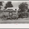 Farmer moving in wagon from farm to a new farm. He had stopped for rest and repair along roadside in Smith County, Texas